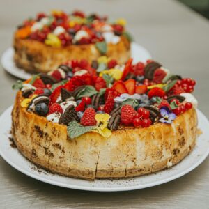 A delectable cheesecake topped with fresh berries and cookies, perfect for dessert lovers.