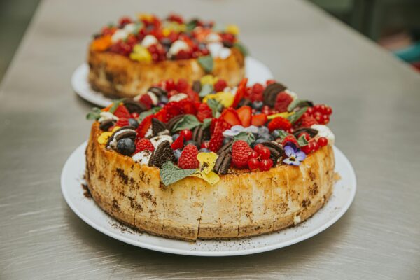 A delectable cheesecake topped with fresh berries and cookies, perfect for dessert lovers.